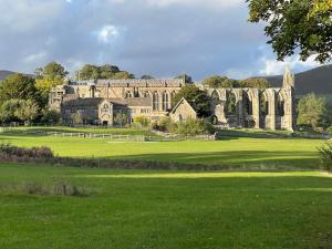 a large building in a field with a green field at The Folly in Draughton