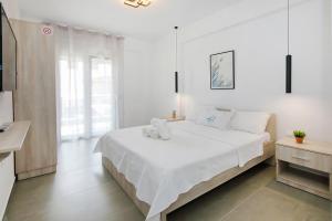 a white bedroom with a large white bed in it at AR APARTMENTS in Nikiti
