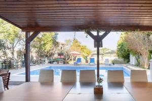 een patio met een tafel en stoelen en een zwembad bij A villa located in the middle of the mountains .. in Trimitusa