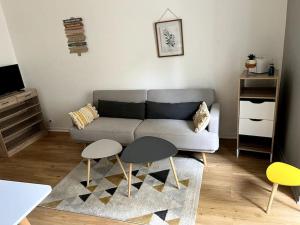 a living room with a couch and two tables at Appartement centre historique Monségur in Monségur