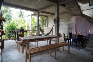 a patio with a wooden table and a bench at PASSIONFRUIT HOMESTAY in Matara