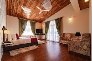 sypialnia z łóżkiem, kanapą i krzesłem w obiekcie Windermere Hotel w mieście Shillong