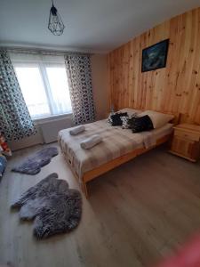 MizernaBodziuchówka的卧室配有一张大床，墙壁为木质