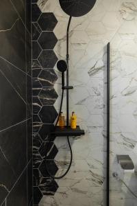 een douche in een badkamer met een zwart-witte muur bij Green Resort Bran in Bran
