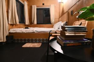 una stanza con un tavolo con una pila di libri di Tenpy Tiny Scenic Garfield @ T-Stop, Coorg a Virajpet