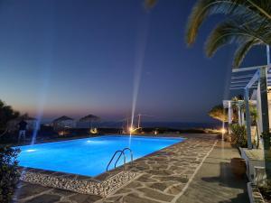 a swimming pool in a resort at night at Bellevue Village ''Αdults Only'' in Agia Pelagia
