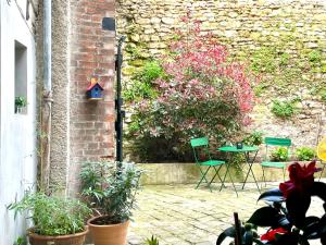 a patio with a table and chairs and plants at Vieux Marly-le-Roi - Studio bien equipé - Matelas haut qualité in Marly-le-Roi