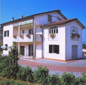 - un grand bâtiment blanc avec un panneau dans l'établissement HOTEL SAN FRANCESCO INN, à Stroncone