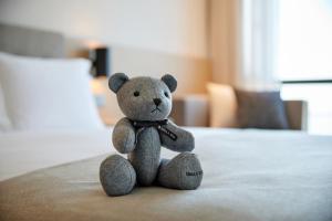 a teddy bear sitting on top of a bed at Shilla Stay Plus Ihotewoo in Jeju