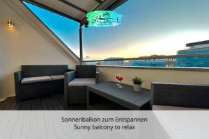einen Balkon mit 2 Stühlen und einem Tisch auf dem Dach in der Unterkunft Auszeit Apartment SUNNY in Friedrichshafen