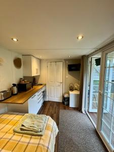 a kitchen with a bed in the middle of a room at Apple tree hut, in a private garden in Skipton