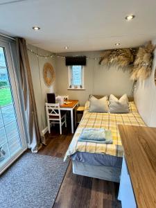 a bedroom with a bed and a desk and a table at Apple tree hut, in a private garden in Skipton