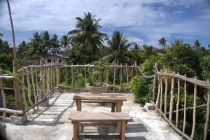 a table and benches on a balcony with palm trees at PASSIONFRUIT HOMESTAY in Matara