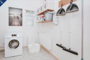 eine weiße Waschküche mit Waschmaschine in der Unterkunft Haus Mertin Whg 4 Seepferdchen in Heringsdorf