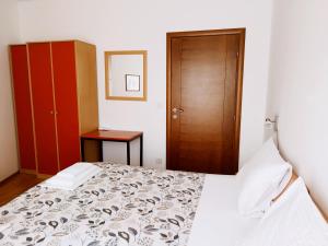 Schlafzimmer mit einem Bett und einer Holztür in der Unterkunft Apartments Dubravka Budva in Budva