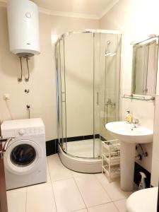 ein Badezimmer mit einer Dusche, einer Waschmaschine und einem Waschbecken in der Unterkunft Apartments Dubravka Budva in Budva