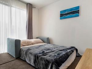 a bedroom with a bed and a large window at Entire Brand New Home in Christchurch