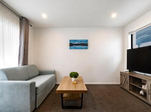 a living room with a couch and a table at Entire Brand New Home in Christchurch
