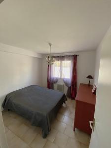 um quarto com uma cama, uma mesa e uma janela em T3 62m2 + terrasse ensoleillée Toulon em Toulon