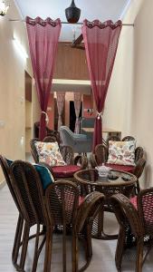 ein Wohnzimmer mit einem Tisch, Stühlen und einem Sofa in der Unterkunft Bobby’s B&B in Lucknow