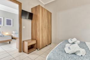 a bedroom with a bed and a wooden cabinet at Contessa Hotel in Argasi