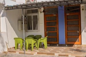 - un ensemble de chaises vertes assises sur une terrasse dans l'établissement Bobby’s B&B, à Lucknow