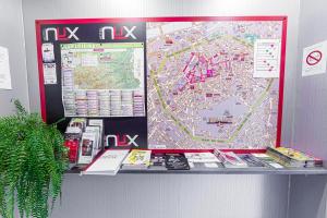 une grande carte au-dessus d'un comptoir avec des livres dans l'établissement Nyx Hôtel Indépendant, à Perpignan