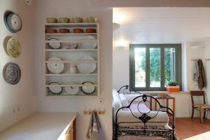 a kitchen with plates and bowls on a shelf at Dolly's Dream House in Patmos