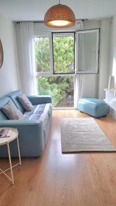 sala de estar con sofá azul y ventana grande en Apartment Las Salinas Boliches, en Fuengirola