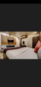 um quarto de hotel com uma cama grande e uma televisão em Hotel Green Park em Mumbai