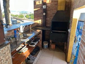 a kitchen with a sink and a stove at Muito Confortável AP203p in Rio de Janeiro