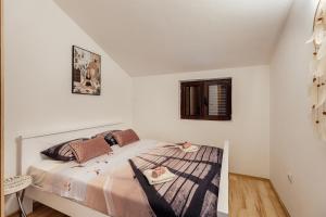 ein Schlafzimmer mit einem Bett mit zwei Puppen drauf in der Unterkunft Apartments Kosta in Tivat