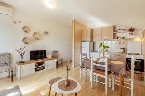 eine Küche und ein Wohnzimmer mit einem Tisch und Stühlen in der Unterkunft Apartments Kosta in Tivat
