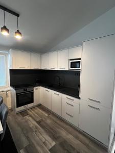 a kitchen with white cabinets and black counter tops at Katarína in Kežmarok