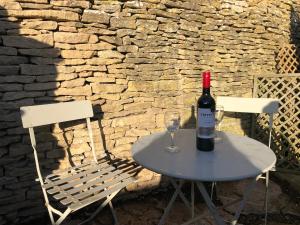 uma mesa com uma garrafa de vinho e um copo em Green Valley, Cotswold stay with hamper em Cheltenham