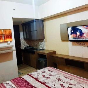 een kamer met een keuken en een tv aan de muur bij OYO 93831 Penginapan Cisauk in Tangerang