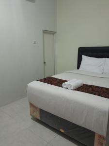 a bedroom with a bed with two towels on it at Jogja Amor Hotel in Demangan