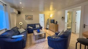 ein Wohnzimmer mit 2 blauen Sofas und einem Tisch in der Unterkunft Villa Le Bon Temps in Mandelieu-la-Napoule