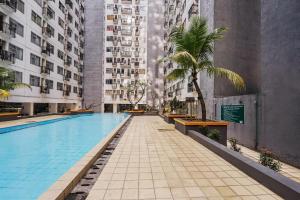 a swimming pool in a building with tall buildings at OYO 93834 The Jarrdin Apartment By Yedi Property in Bandung