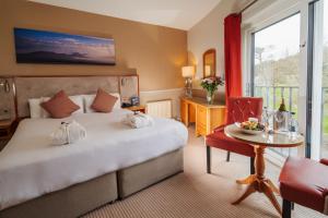 Cette chambre comprend un grand lit et une table avec table. dans l'établissement Clew Bay Hotel, à Westport