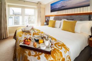 Una habitación de hotel con una cama con una bandeja de comida. en Clew Bay Hotel, en Westport
