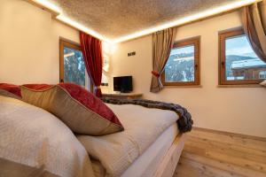 a bedroom with a bed and two windows at Mas del Mezdì - mountain chalet Val di Rabbi in Rabbi