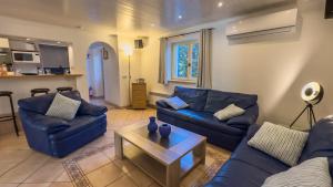 ein Wohnzimmer mit blauen Sofas und einem Couchtisch in der Unterkunft Villa Le Bon Temps in Mandelieu-la-Napoule
