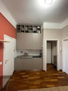 een keuken met witte kasten en een houten vloer bij Città studi - Apartment in Milaan