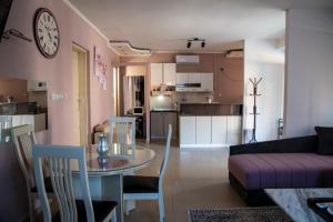 sala de estar y cocina con mesa y sofá en Apartman Lara, en Kuršumlija