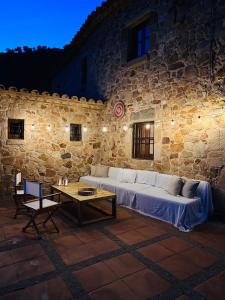 um edifício de pedra com um sofá e uma mesa em B&B La Vista Brava em Platja d'Aro
