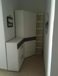 Habitación con armario blanco y estante. en Apartment Julia en Supetarska Draga