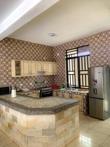 a kitchen with a refrigerator and a counter top at BELINDA APPARTEMENT in Rubavu