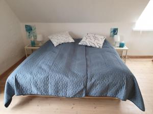 a bed with a blue comforter in a bedroom at SKAU Beach View in Aabenraa