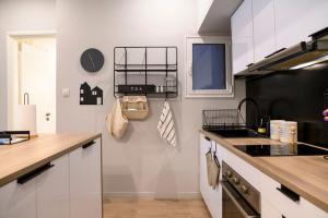 a kitchen with white cabinets and a counter top at Cosy Contemporary Luxury Urban Retreat in Athens in Athens